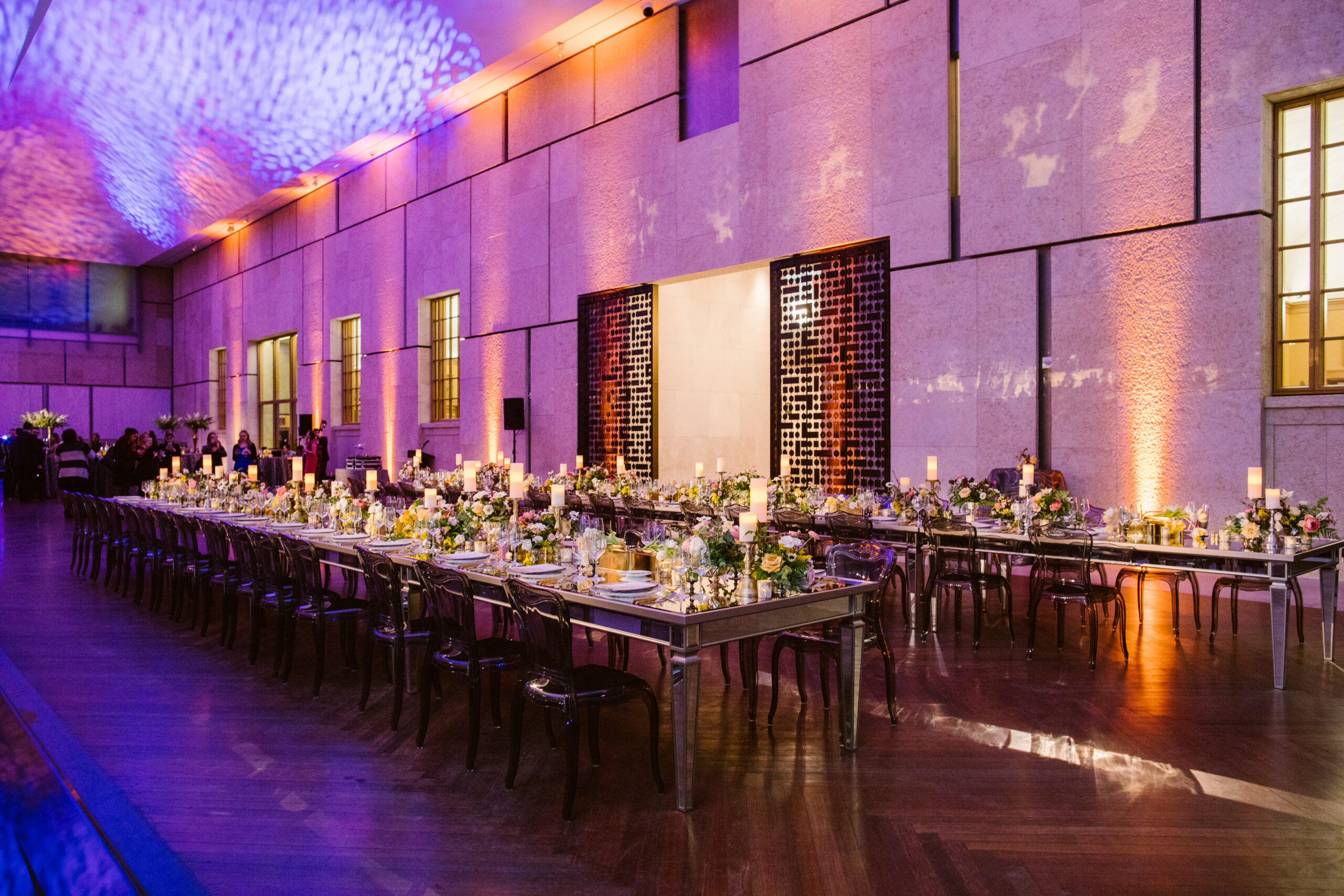 Colorfully lit room with long banquet tables 