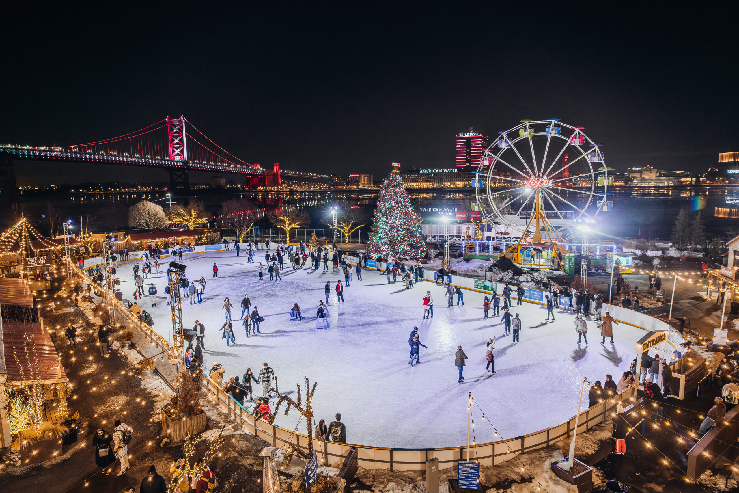 night time shot of ice rink and ferris wheel 
