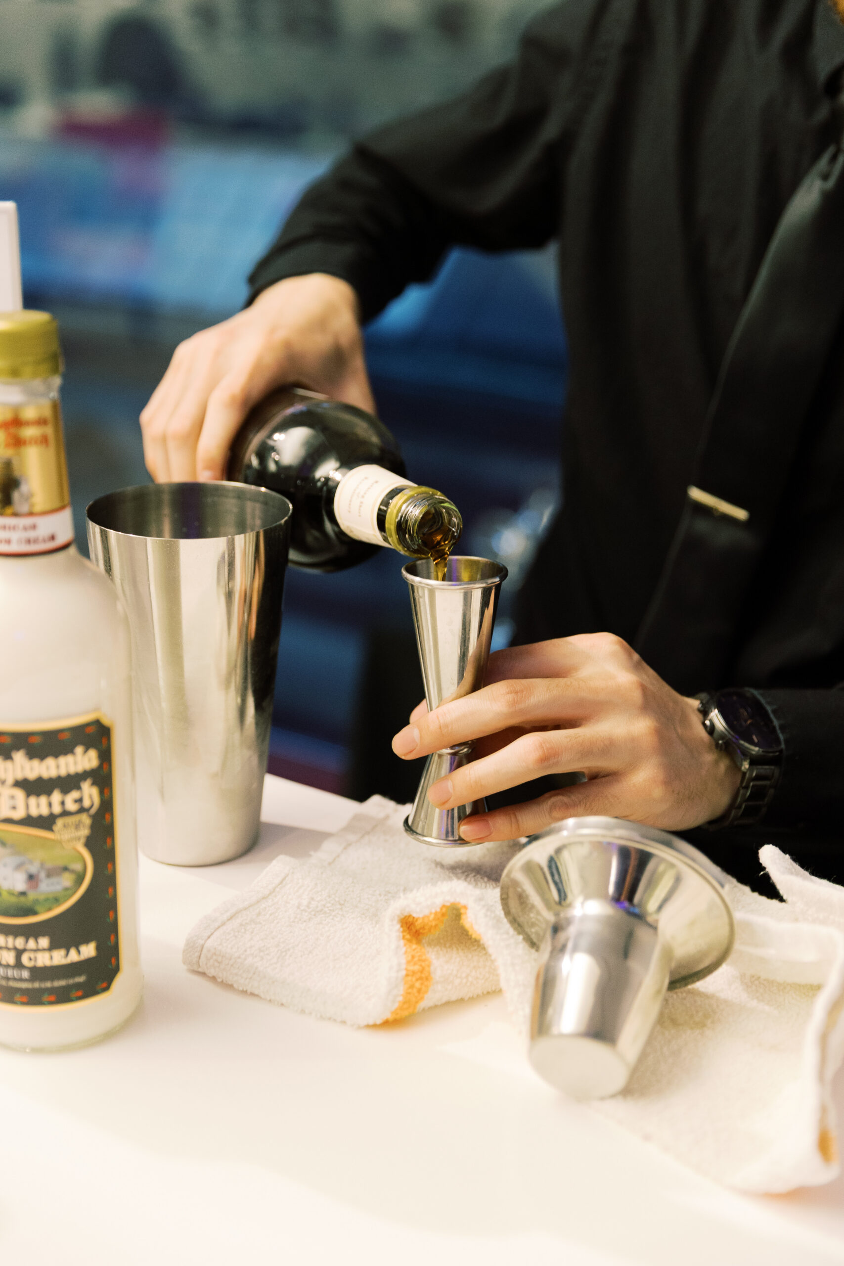 close up shot of bartender measuring out shots for a drink